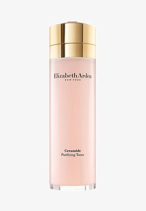 Klar glasflaska med ett guldlock, som innehåller rosa vätsketoner. Har svart text: "Elizabeth Arden" och "Ceramide Purifying Toner."