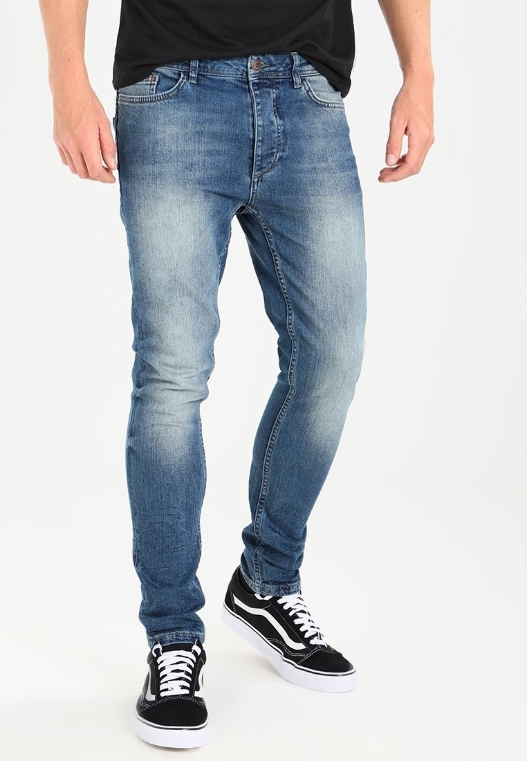 Ljusblå denimjeans med smal passform, med en blekt tvätt, fem fickor och dragkedja. Matcher med svarta och vita sneakers.