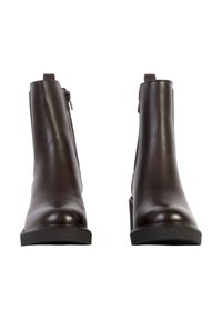 Paire de bottines en cuir marron foncé avec fermetures éclair latérales et semelles plates noires, présentées de face sur un fond blanc.