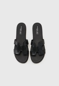 Svarta slidesandaler med två texturerade, korsade remmar med glittrande finish och en slät svart sula.