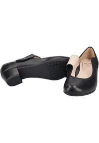 Chaussures à talons en cuir noir avec un bout rond, présentant un petit design découpé et une semelle en caoutchouc texturé pour une bonne adhérence.