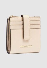 Portafoglio in pelle beige con scomparti per carte e chiusura magnetica. Presenta un marchio impresso a rilievo e una texture liscia. Forma rettangolare compatta.