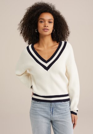 Weißer Strickpullover mit einem tiefen V-Ausschnitt, der marineblaue gestreifte Akzente am Kragen und an den Bündchen hat. Weiche Textur mit gerippten Details.