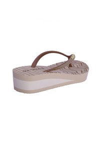 Chanclas de plataforma beige con una plantilla texturizada, tiras marrones y acentos dorados. La suela presenta patrones ondulados para mayor tracción.