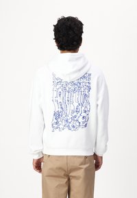 Sudadera blanca con un diseño gráfico azul en la parte posterior. El diseño incluye formas abstractas y elementos florales. Fabricada con tela suave.