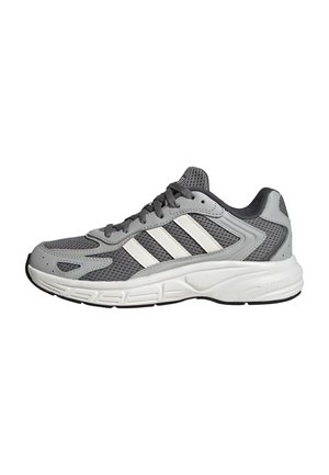 Grauer und weißer Sportschuh mit Mesh-Obermaterial, weißer Sohle, schwarzer Außensohle und Schnürverschluss, von der Seite gesehen.