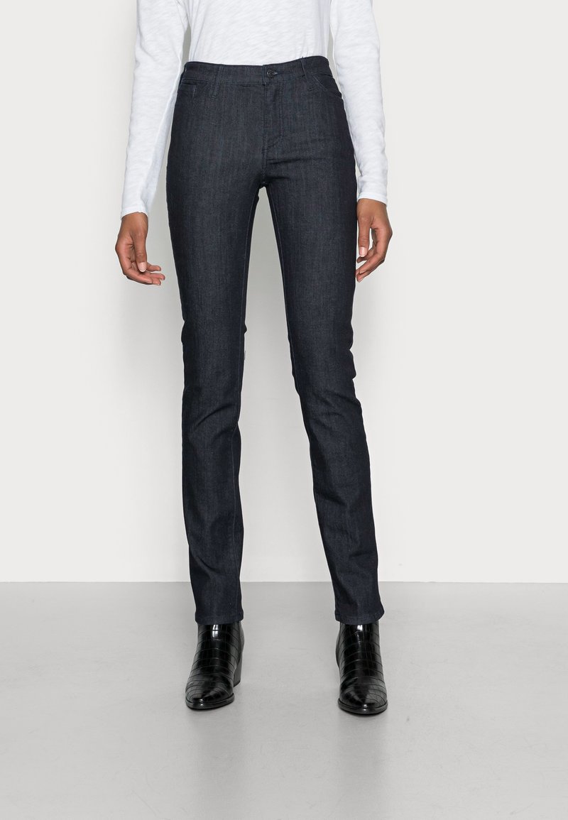 Pantalon en denim bleu foncé à coupe ajustée, doté d'une fermeture à boutons et zip, d'un design à cinq poches et de détails de couture subtils.