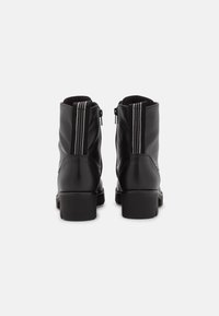 Stivali ankle in pelle nera con finitura testurizzata, dotati di tacco a blocco e cerniera laterale, accentuati da due strisce verticali grigie.