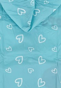 Light blue fabric featuring white heart patterns. The texture appears smooth with a matte finish. The design is repetitive and playful.