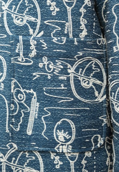 Μπλε ύφασμα με λευκά αφηρημένα σχέδια, που περιλαμβάνουν παιχνιδιάρικα σχέδια, υφές και ποικίλες παχιές γραμμές για οπτικό ενδιαφέρον.