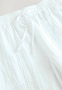 Vita, lätta bomullsshorts med resårmidja och snörning, subtil textur och sidofickor.