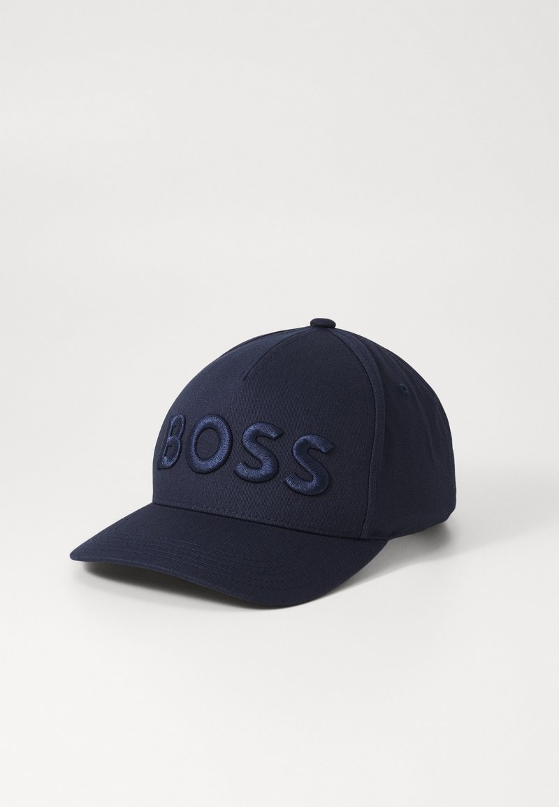 Casquette de baseball bleu marine avec visière incurvée et texte brodé en relief "BOSS" sur le panneau avant, présentée sur un fond blanc.