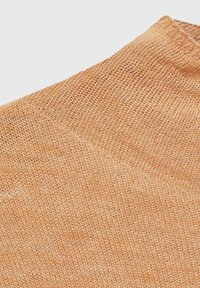 Lichtoranje gebreide stof met een losse, open weeftextuur en een subtiele ribbelrand bij de hals. Geschikt voor casual kleding.