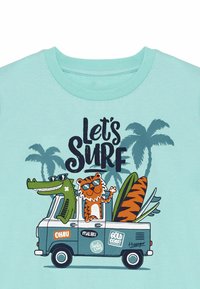 Světle modré tričko s barevným kresleným alligátorem a tygrém v retro dodávce se surfovacími prkny. Text zní "Pojďme surfovat."