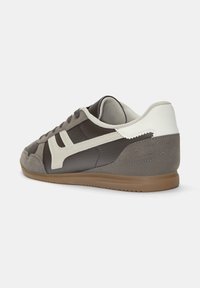 Sneaker in pelle marrone e camoscio grigio con dettagli bianchi. Punta arrotondata, suola piatta e colletto imbottito per il comfort.