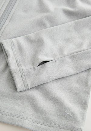 Hellgraues Langarmoberteil mit glatter Textur, ausgestattet mit einem kleinen Daumenloch am Bündchen und dezentem Logo-Stickerei.