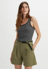 Gray ribbed tank top paired with high-waisted olive green shorts featuring pleats, traditional pockets, and a braided black belt.