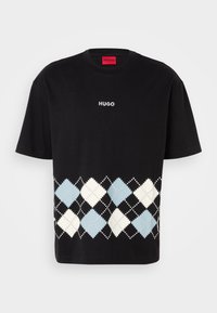 Schwarzes Baumwoll-T-Shirt mit einem weißen "HUGO"-Logo, das ein unteres Argyle-Muster in hellblauen und cremefarbenen Rauten mit schwarzen Akzenten aufweist.