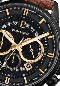 Reloj cronógrafo negro con acentos dorados. Tiene un dial texturizado, manecillas luminosas y ventana de fecha. La correa de cuero marrón completa el diseño.
