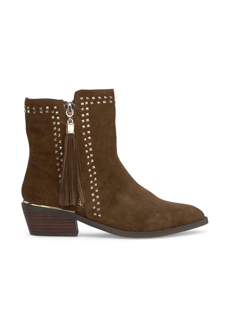 Stivaletto in suede marrone con punta affusolata, chiusura con zip, dettagli borchiati sui lati e un tassello vicino alla zip. Tacco basso impilato.
