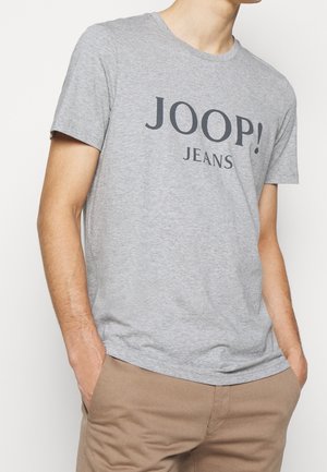 T-shirt en coton gris avec un logo noir « JOOP! JEANS » imprimé à l'avant. Manches courtes et col rond.