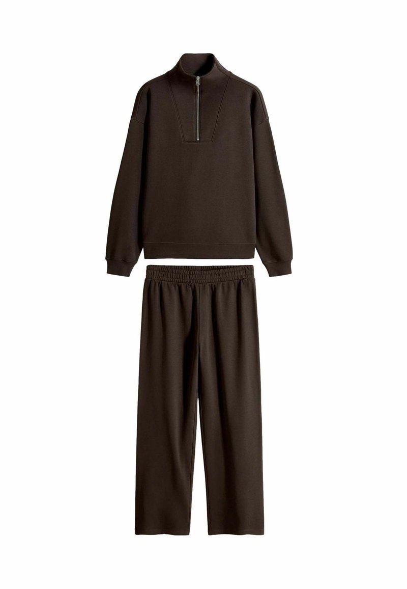 Mørkebrun træningsdragtsæt, der inkluderer en sweatshirt med høj krave og lynlås samt paneldesign og matchende bukser med elastisk talje. Blød stofstruktur.