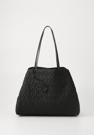Black quilted tote bag with floral pattern, flat base, and two shoulder straps. Includes a rectangular tag attached to the handle.