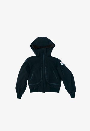 Melnas kapuces jaka ar pilnu priekšējo rāvējslēdzēju, vairākām rāvējslēdzēju kabatām, elastīgām aprocēm un mazu uzlīmi augšējā kreisajā piedurknes pusē.