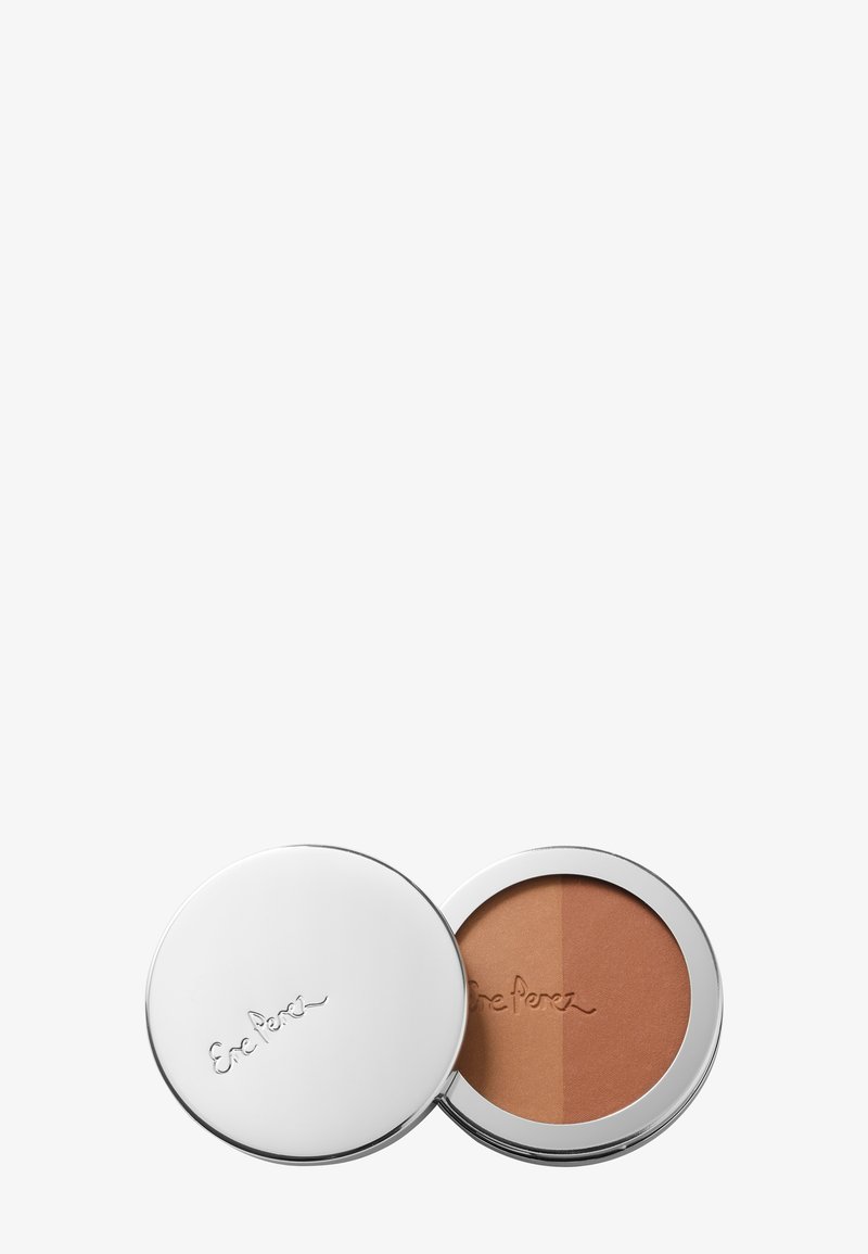 Bronzer compact avec un extérieur argenté miroir, présentant une surface de poudre bronzante divisée. Texture lisse avec un logo embossé sur le couvercle.
