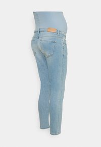 Graviditetsskinny jeans i ljusblå denim. Har en mjuk, elastisk midja och traditionell femfickorsdesign. Lätt urtvättad finish.