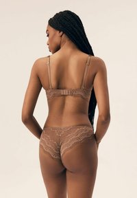 Brązowy zestaw bielizny koronkowej z misternymi wzorami, regulowanymi ramiączkami i zapięciem na plecach. Miękka, przezroczysta tkanina o teksturowanym wykończeniu.