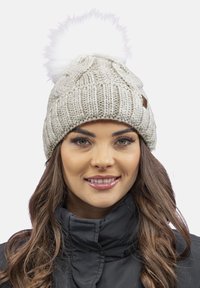 Lichtgrijze gebreide beanie met een gestructureerd patroon, voorzien van een fluffy witte pompon bovenop en een klein bruin label aan de zijkant.