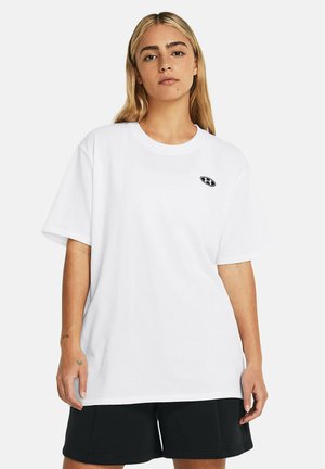 Camiseta de algodón blanca con cuello redondo y mangas cortas. Presenta un pequeño logo negro en el área izquierda del pecho.