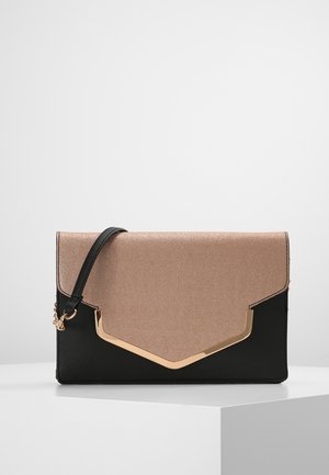 Pochette rectangulaire bicolore avec rabat en métal rose doré et base noire, ornée d'un bord doré et d'une courte bandoulière noire pour le poignet.