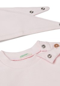 Světle růžová dětská košile s žebrovanou texturou, kulatým výstřihem a zapínáním na patentní knoflíky. Obsahuje štítek s nápisem "United Colors of Benetton."