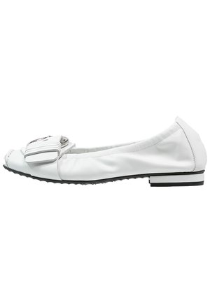 Chaussure plate en cuir blanc avec une boucle argentée décorative et une semelle en caoutchouc noire, vue de profil sur fond blanc.