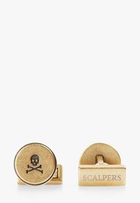 Gemelos de bronce con forma redonda que presentan un diseño de calavera y huesos cruzados en un lado y "SCALPERS" grabado en el otro lado.