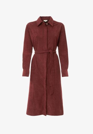 Vestito camicia in velluto a coste color marrone rossiccio con maniche lunghe, bottoni frontali e cintura in vita. Tessuto liscio con colletto classico e polsini risvoltati.