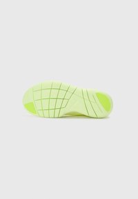 Bright yellow-green sneaker sole with a textured surface, featuring a grid pattern and rubber accents, designed for traction and support.