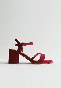 Sandali con tacco in suede rosso, con plateau spesso, design open toe e due sottili cinturini sul piede; cinturino alla caviglia regolabile con fibbia in metallo.