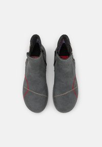Bottines en suède gris avec des coutures rouges et crème, fermeture éclair et doublure texturée. Design incurvé avec bout arrondi.