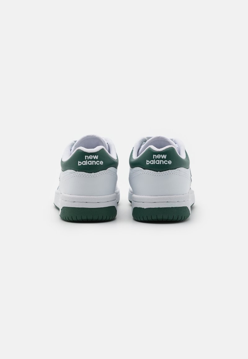 Sneakers bianchi con dettagli verdi, suole in gomma testurizzata e logo in rilievo sul tallone. Design classico a bassa altezza con tomaia in pelle liscia.
