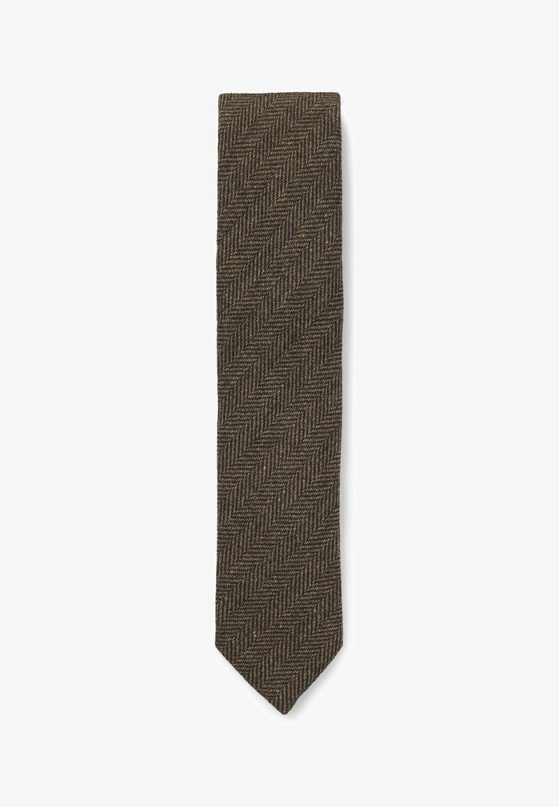 Brun herringbone slips med en texturerad tygkonstruktion i smal form, med en spetsig spets och intrikat vävd mönster.