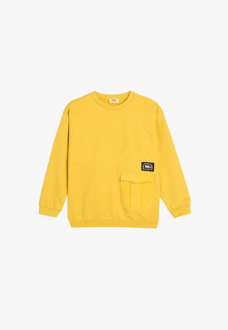 Sudadera amarilla de algodón, con cuello redondo, mangas largas, un bolsillo frontal y una etiqueta negra cosida en el bolsillo.