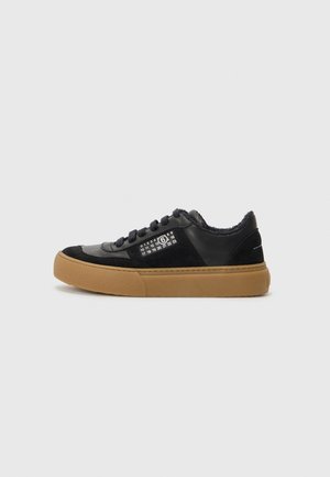 Zapatillas negras con una combinación de cuero y ante, que presentan una suela de goma y detalles de calendario en el lateral. Diseño de corte bajo.