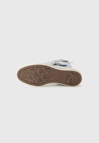 Bl�å høy-topp sneakers med gummisåle, med en teksturert brun yttersåle og dekorativt tilbehør på den øvre delen.