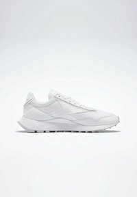 Vit atletisk sneakers med en blandad materialöverdel med släta och texturerade partier. Snörning, vadderad krage och gummisula.