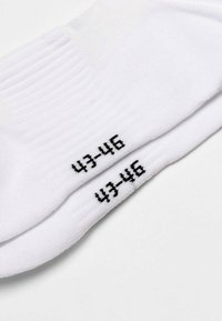 Weiße Baumwollsocken mit geripptem Textur, Größe 43-46 in Schwarz an der Seite gekennzeichnet. Das Design ist einfach und ohne zusätzliche Muster.