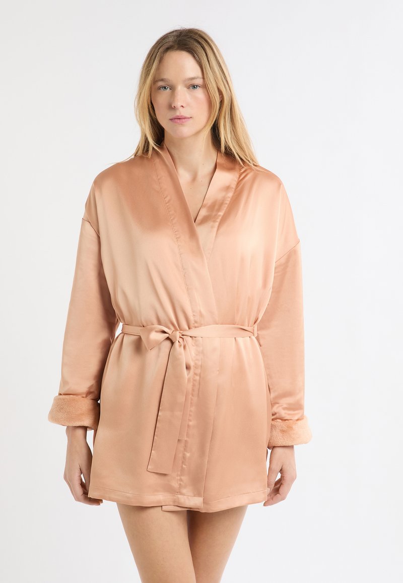 Jasnoróżowy satynowy szlafrok z długimi rękawami, miękkie futrzane akcenty na mankietach, pasek w talii, długość do kolan, gładka faktura, minimalistyczny styl.