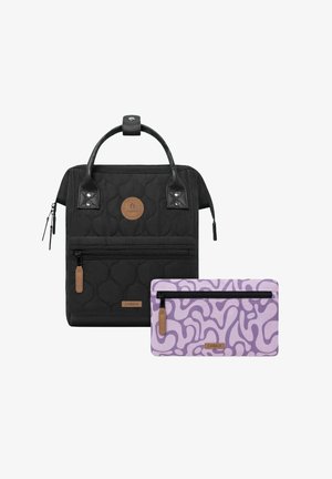 Schwarzer gesteppter Rucksack mit Lederelementen, einem Reißverschlussfrontfach und einem runden Logo. Inklusive einer lavendelfarbenen Geldbörse mit einem Wirbelmuster und Reißverschluss.